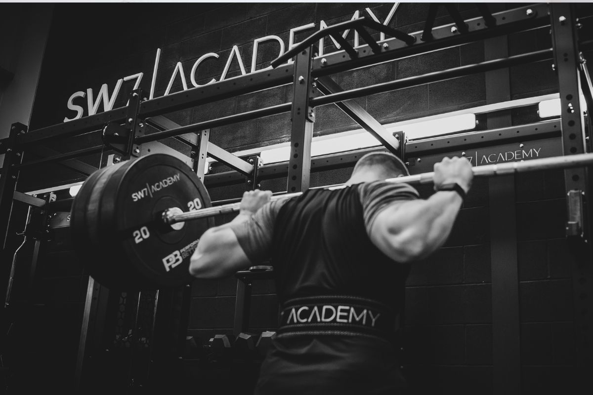 Man squatting with barbell.