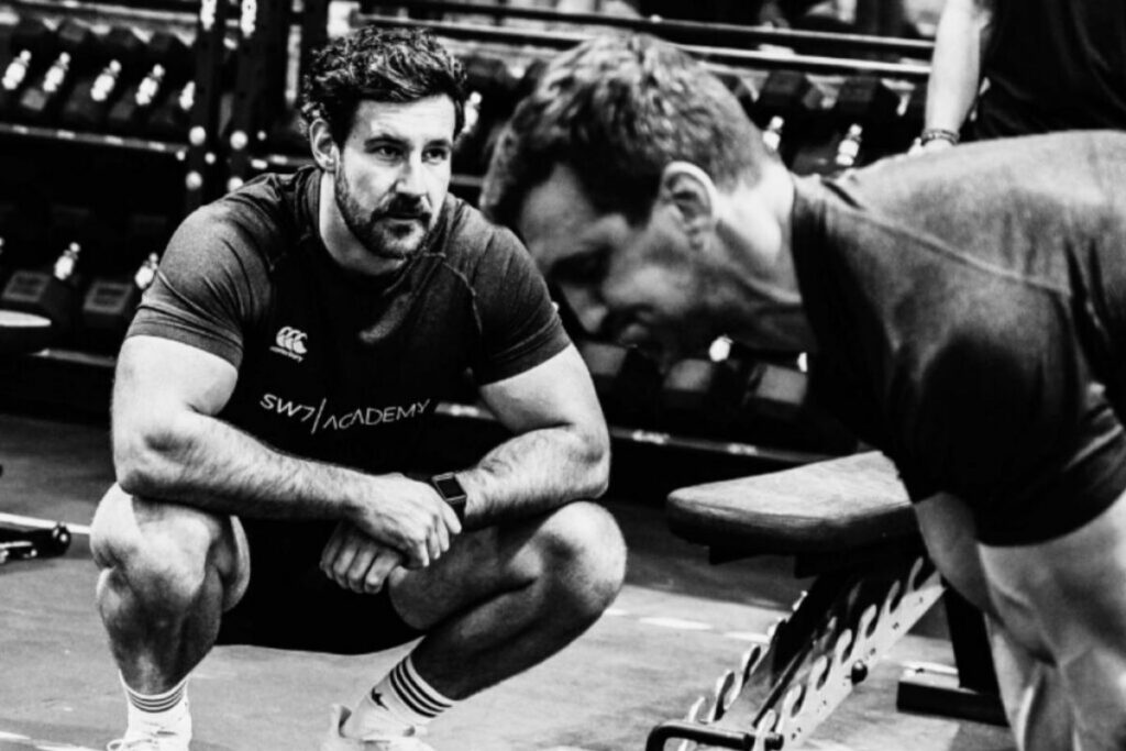 Man working with a personal trainer in the gym.
