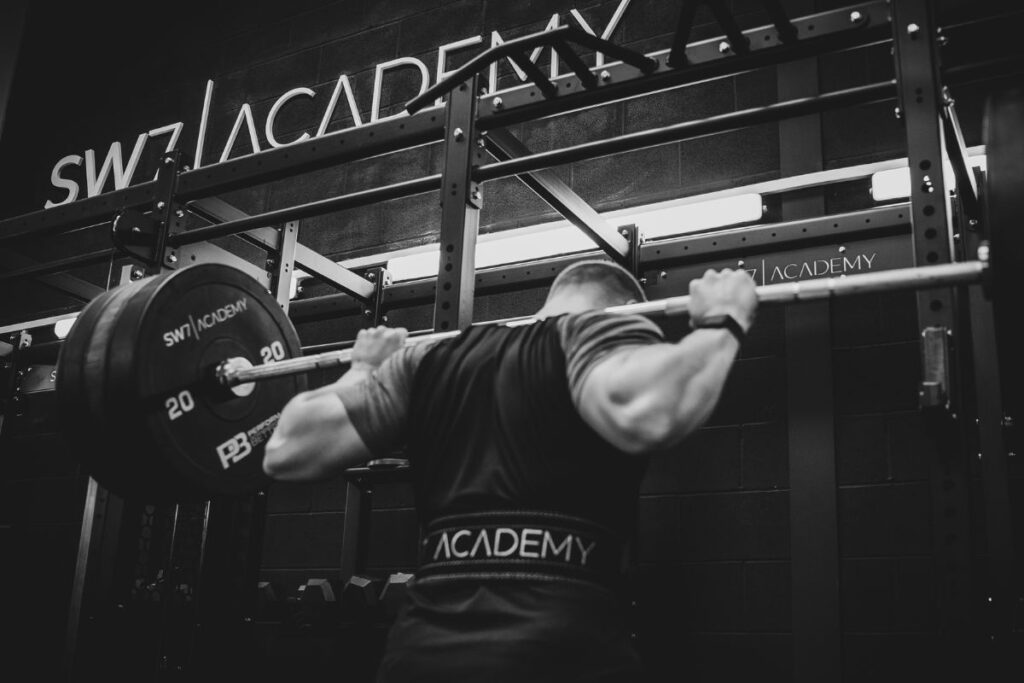 Man squatting barbell.