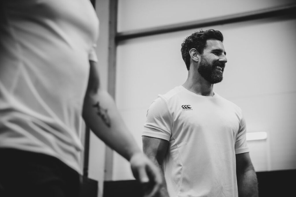 Man standing in front of a mirror smiling looking to the right